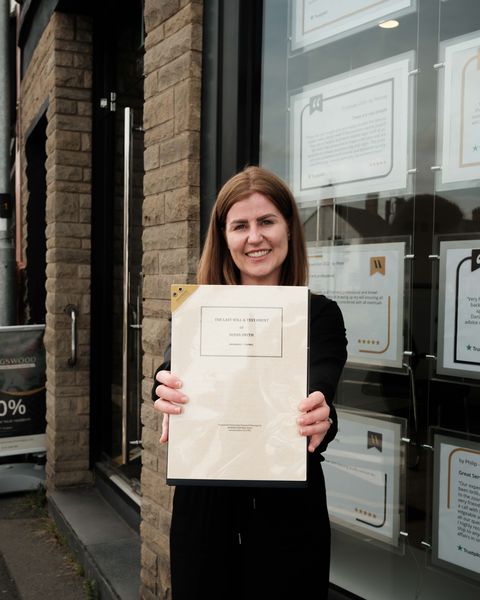 A member of the Kingswood team holding a finished will pack outside the Anstey office